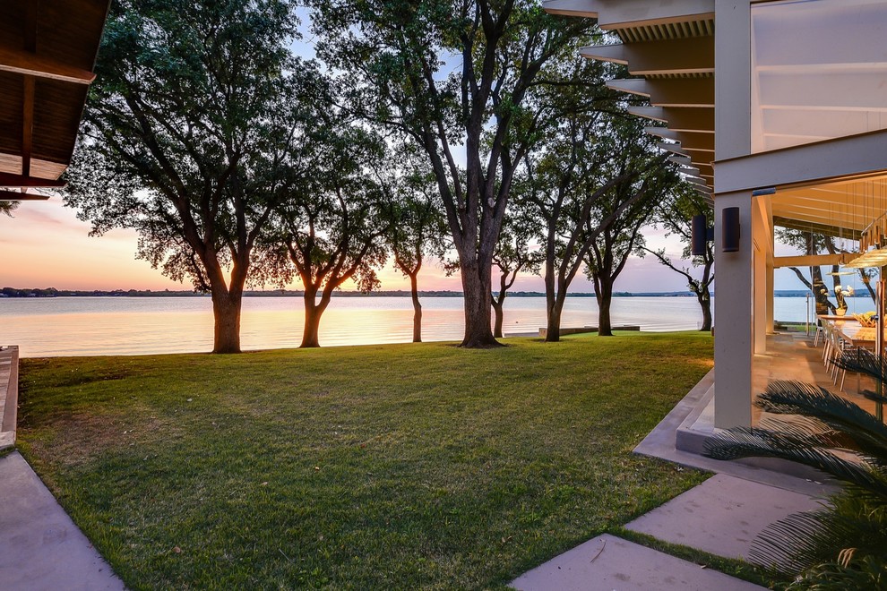 This is an example of a large midcentury two floor glass detached house in Austin with a metal roof.