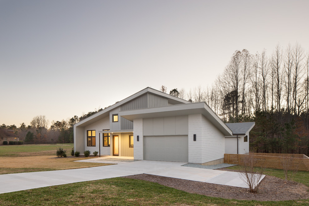Réalisation d'une façade de maison grise minimaliste en panneau de béton fibré de taille moyenne et à un étage avec un toit en appentis et un toit en shingle.