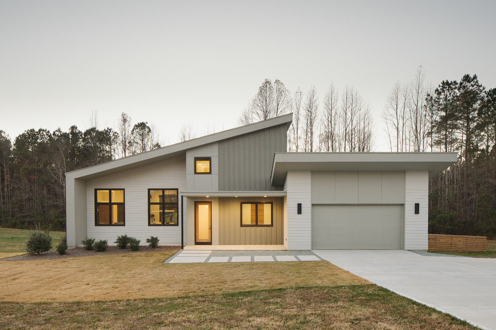 Mid-sized minimalist gray two-story concrete fiberboard house exterior photo with a shed roof and a shingle roof