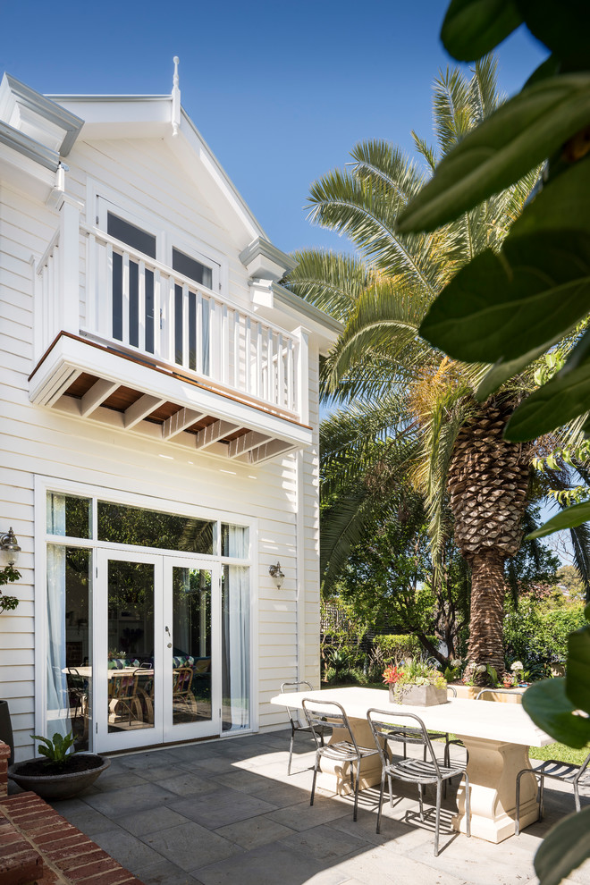 Diseño de fachada de casa blanca marinera grande de dos plantas con revestimiento de madera, tejado a dos aguas y tejado de metal
