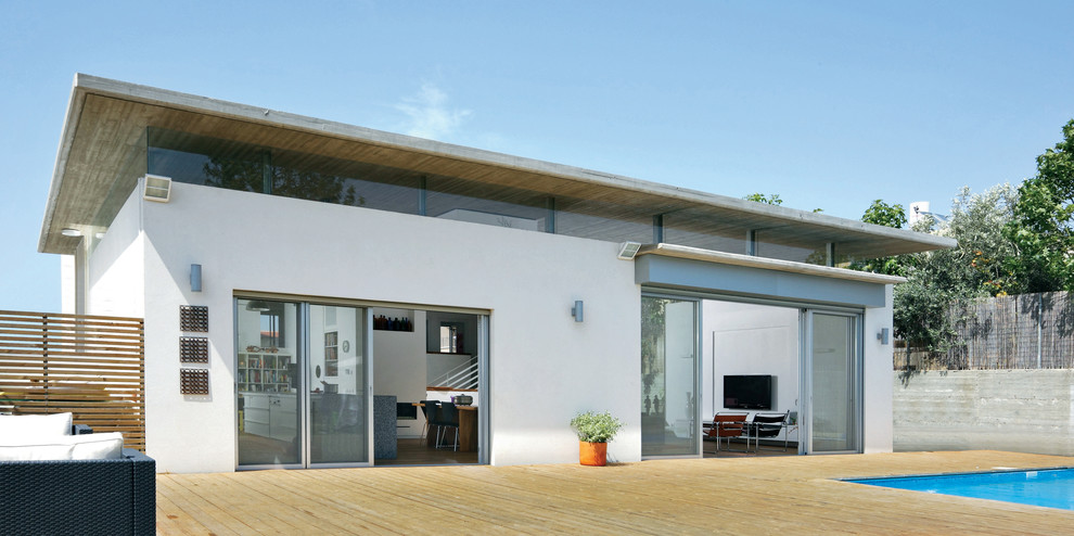 Стильный дизайн: одноэтажный, белый дом среднего размера в стиле модернизм с облицовкой из цементной штукатурки и плоской крышей - последний тренд