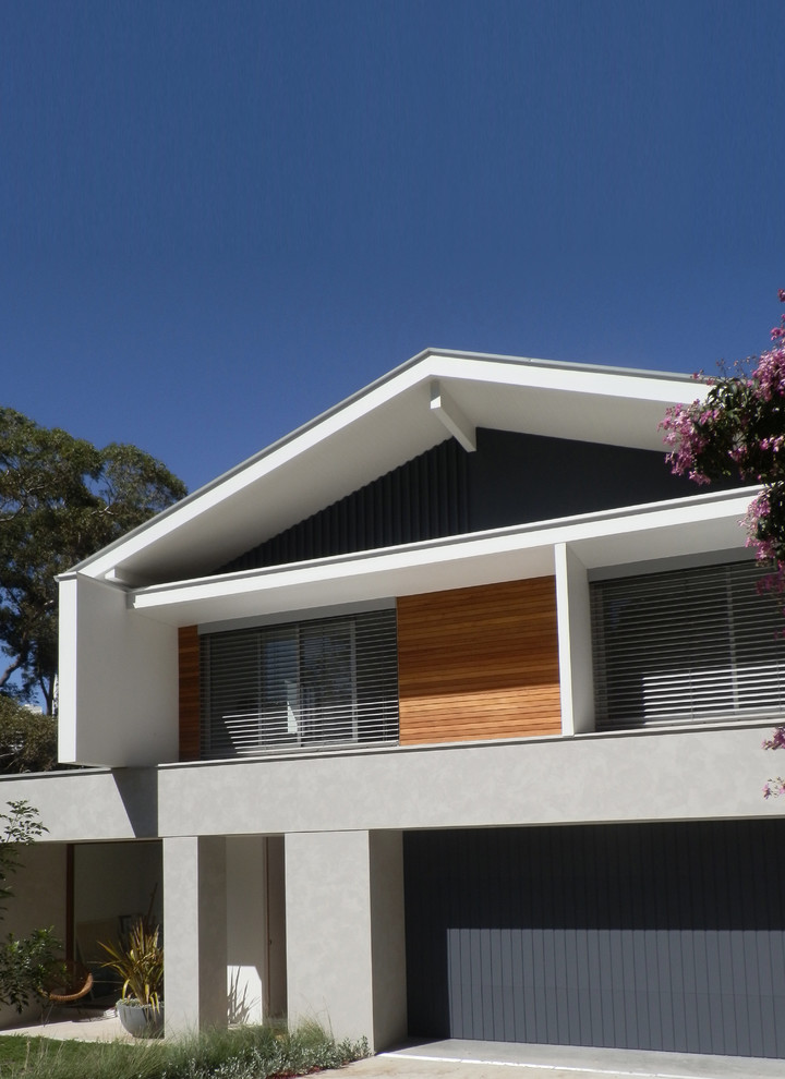 Inspiration pour une grande façade de maison grise design en bois à un étage avec un toit à deux pans.