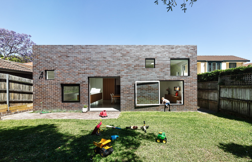 Immagine della facciata di una casa contemporanea a due piani con rivestimento in mattoni e tetto piano