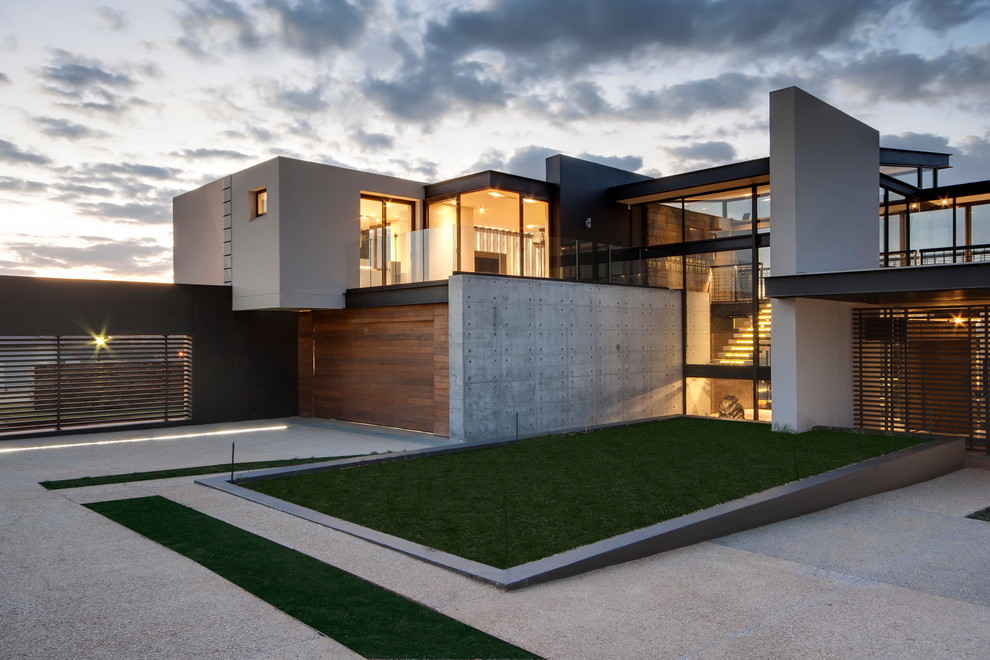 На фото: двухэтажный дом в современном стиле с облицовкой из бетона с