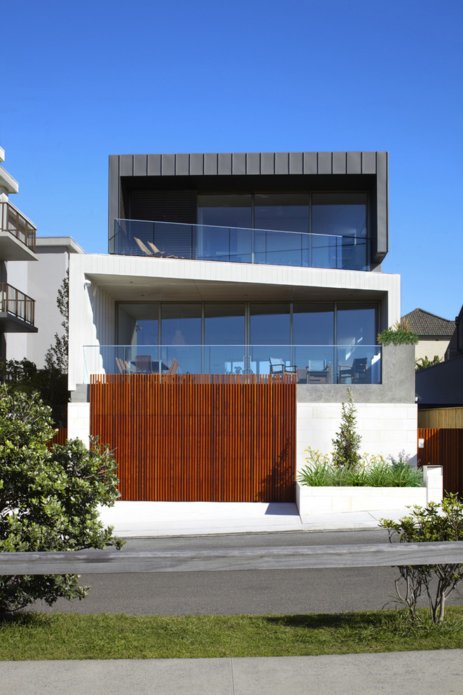 Esempio della facciata di una casa grande moderna a tre piani con rivestimenti misti e tetto piano