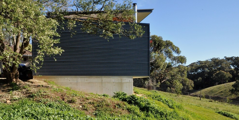 Inspiration för mellanstora moderna blå hus, med allt i ett plan, metallfasad och platt tak