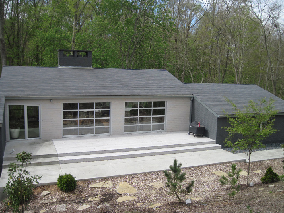Imagen de fachada gris actual de tamaño medio con revestimiento de madera y tejado a cuatro aguas
