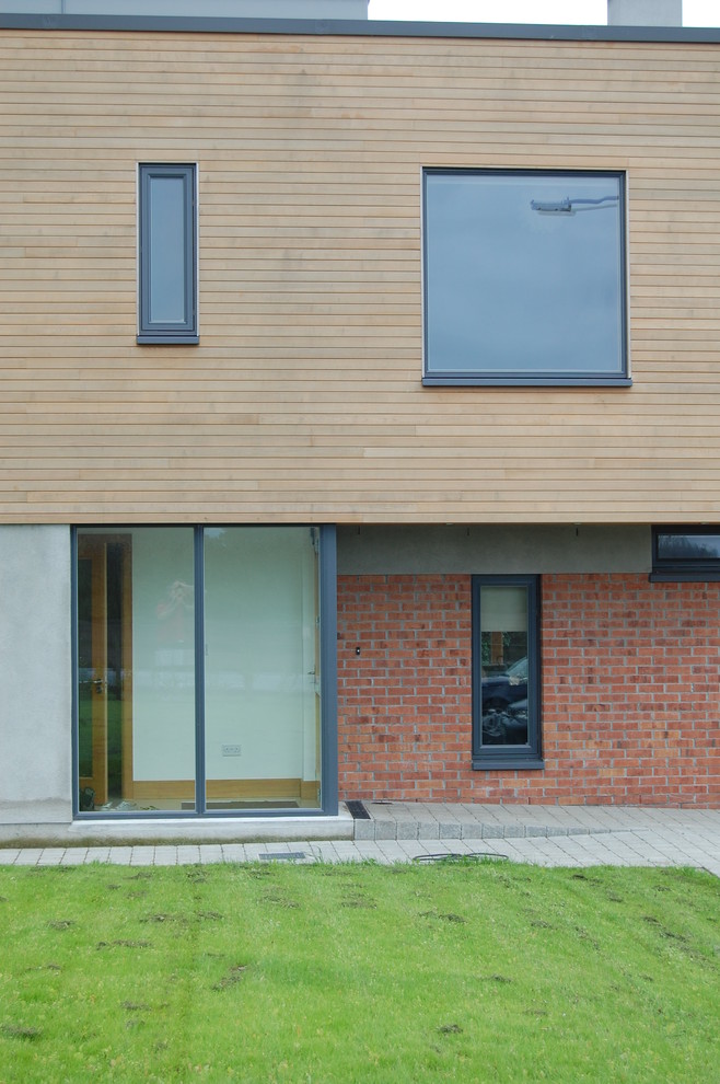 Idee per la facciata di una casa contemporanea a due piani con rivestimento in legno e tetto piano