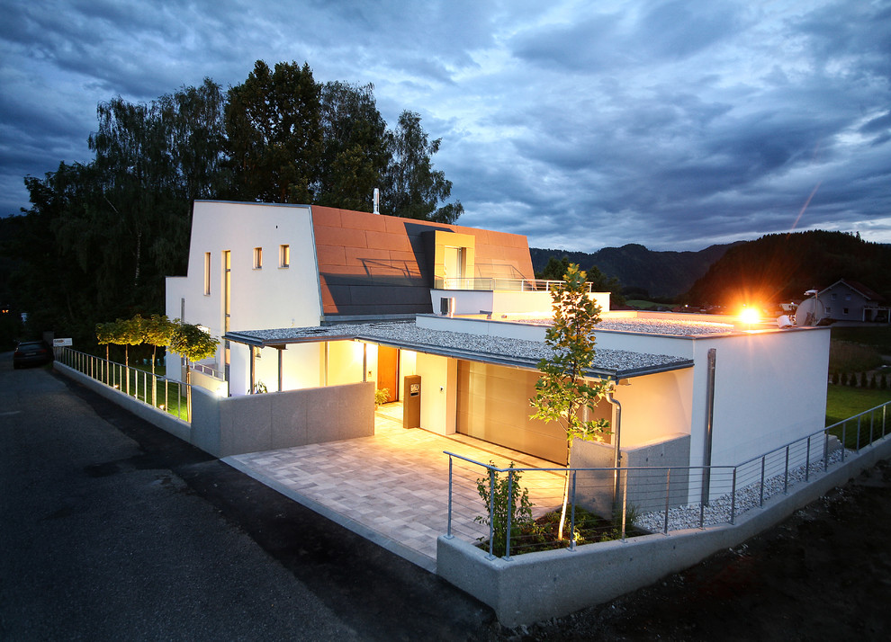 Photo of a white contemporary two floor house exterior in Other with a flat roof.