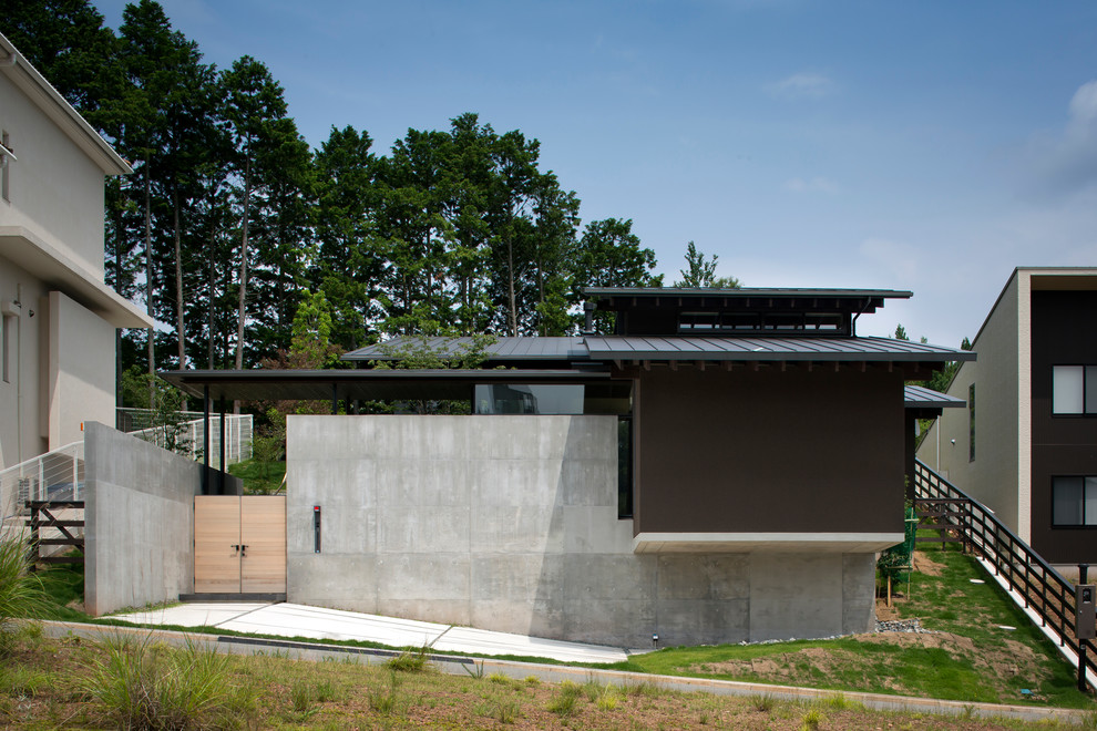Ejemplo de fachada de casa marrón de estilo zen de tamaño medio de dos plantas con revestimiento de hormigón y tejado a dos aguas