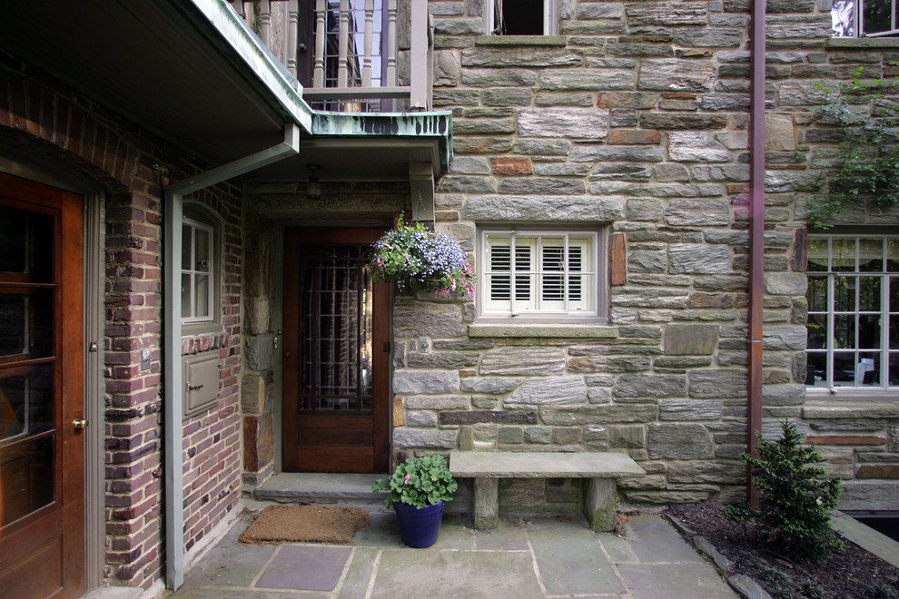 Ejemplo de fachada gris de estilo americano de tamaño medio de tres plantas con revestimiento de piedra