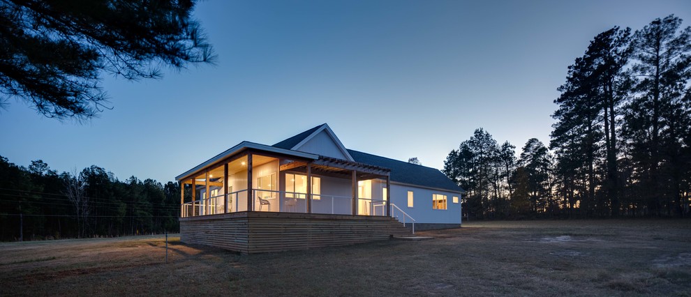 Diseño de fachada de casa blanca de estilo de casa de campo pequeña de una planta con revestimiento de metal, tejado a dos aguas y tejado de teja de madera