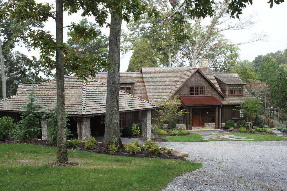 Foto de fachada marrón rústica grande de dos plantas con revestimiento de madera y tejado a dos aguas