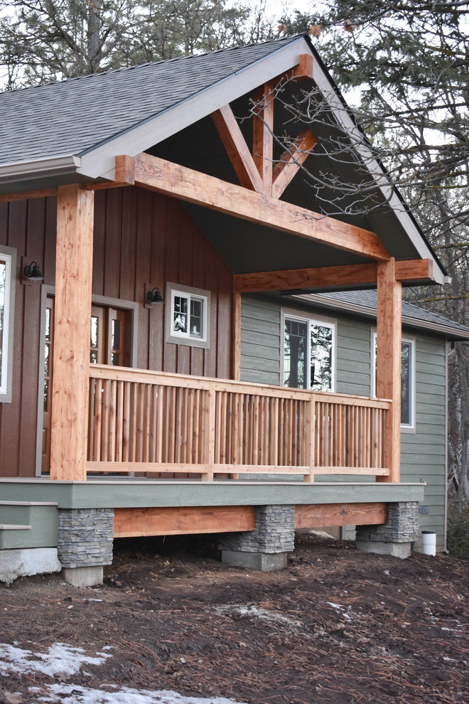 Aménagement d'une façade de maison verte montagne en bois de taille moyenne et de plain-pied avec un toit à deux pans et un toit en shingle.