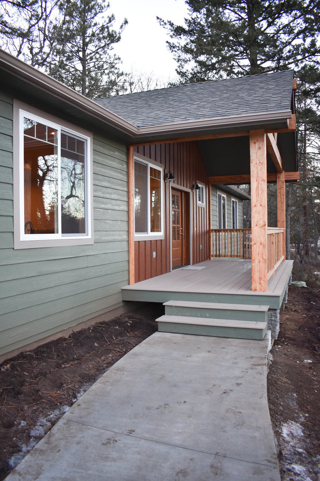 Idées déco pour une façade de maison verte montagne en bois de taille moyenne et de plain-pied avec un toit à deux pans et un toit en shingle.