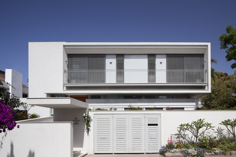 Modelo de fachada blanca minimalista extra grande de dos plantas con revestimiento de estuco y tejado plano