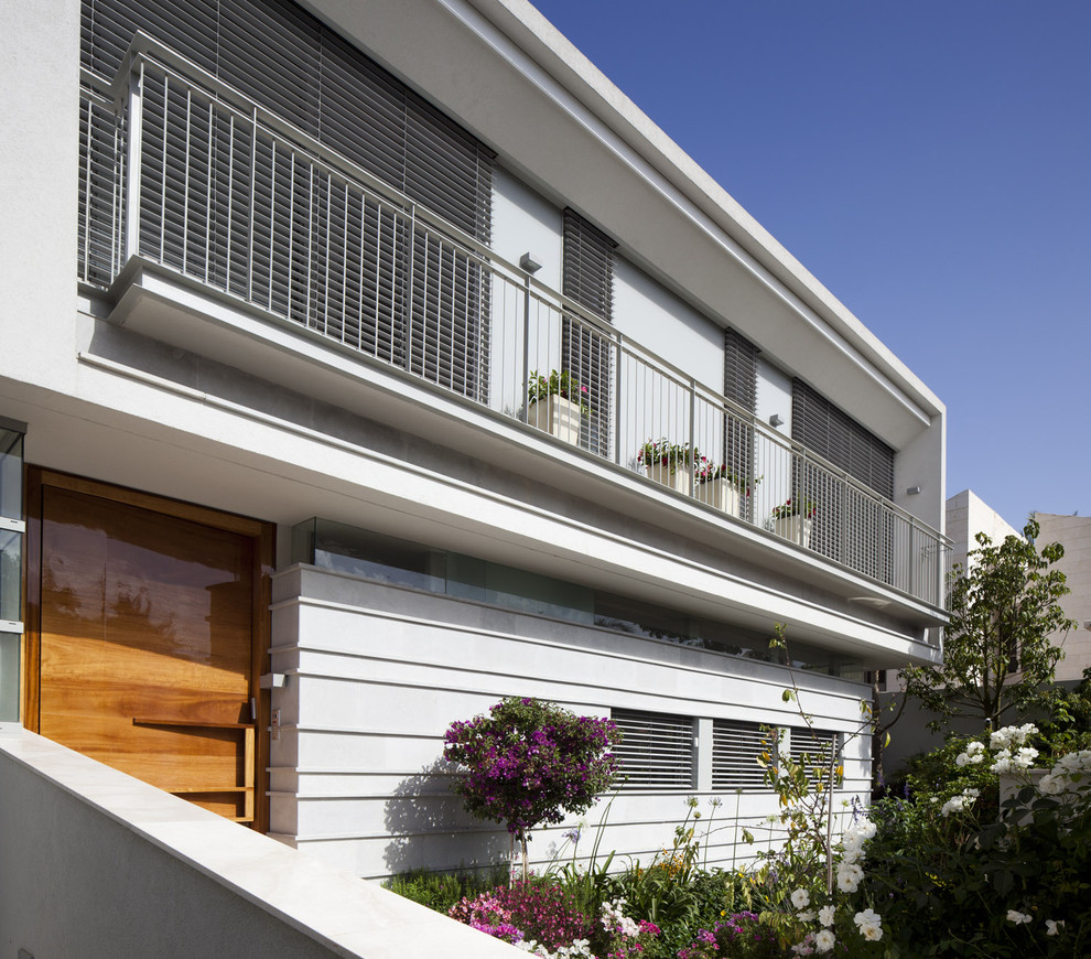 Imagen de fachada blanca moderna extra grande de tres plantas con revestimiento de piedra y tejado plano