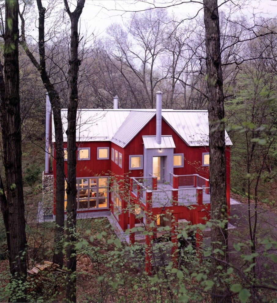 Esempio della villa ampia rossa country a due piani con rivestimento in legno, falda a timpano e copertura in metallo o lamiera