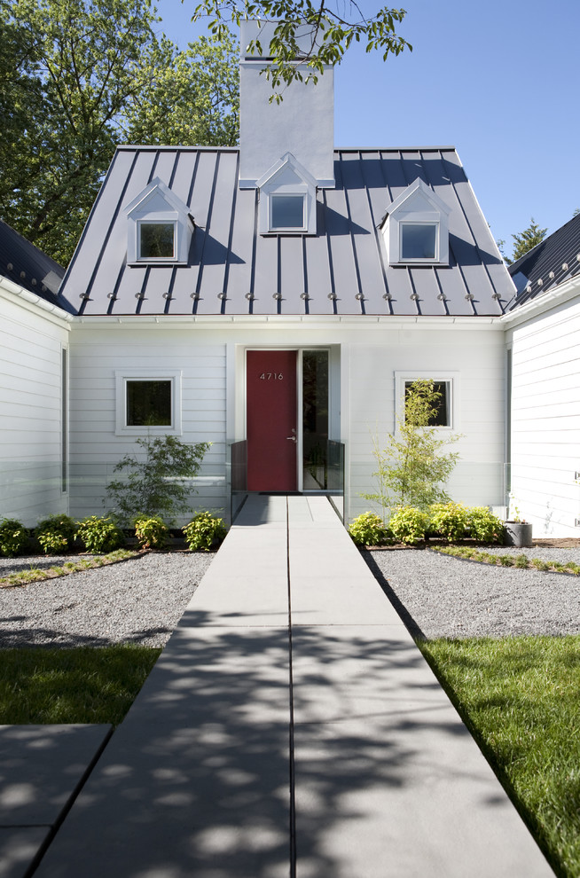 Modelo de fachada de casa blanca clásica renovada grande de una planta con tejado a dos aguas, tejado de metal y revestimiento de vinilo