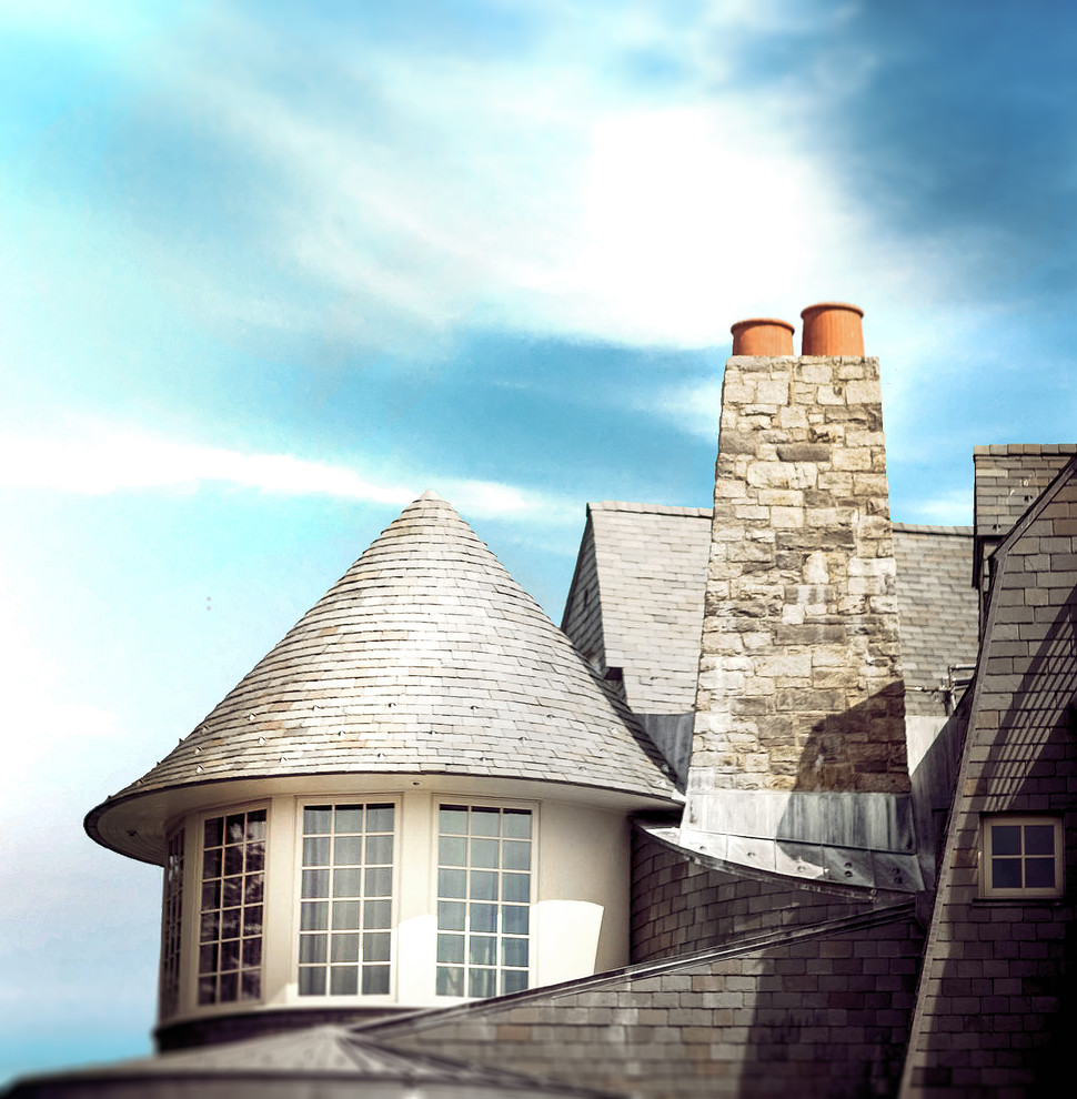 Cette photo montre une très grande façade de maison marron bord de mer en bois à niveaux décalés avec un toit à deux pans et un toit en shingle.