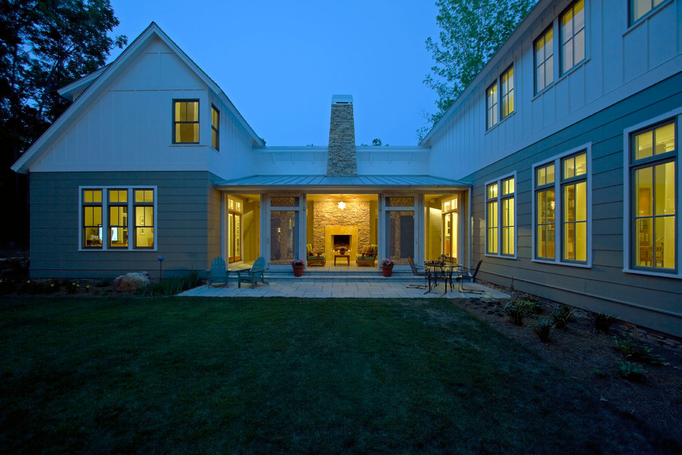 Cette image montre une grande façade de maison verte traditionnelle en panneau de béton fibré à un étage.