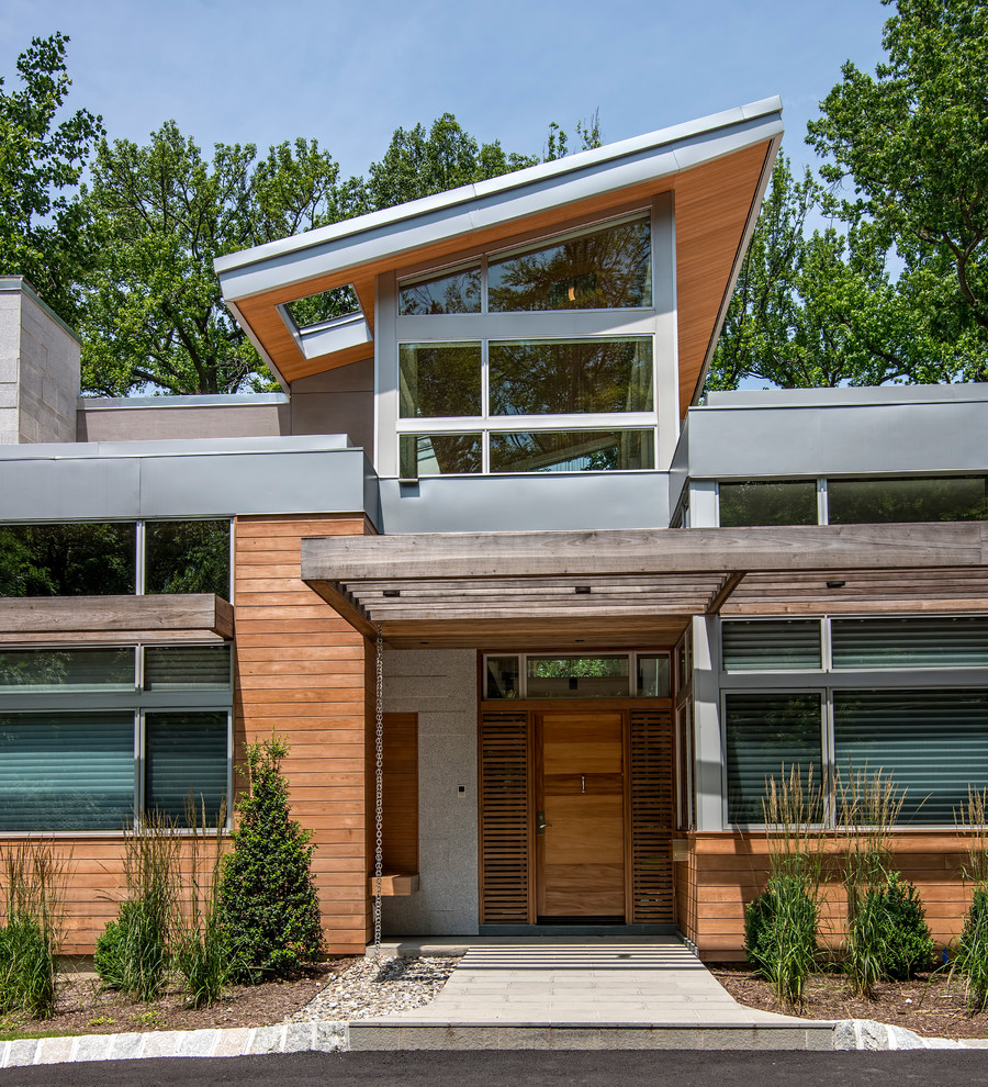 Exemple d'une grande façade de maison multicolore tendance en pierre à un étage avec un toit en appentis et un toit en métal.