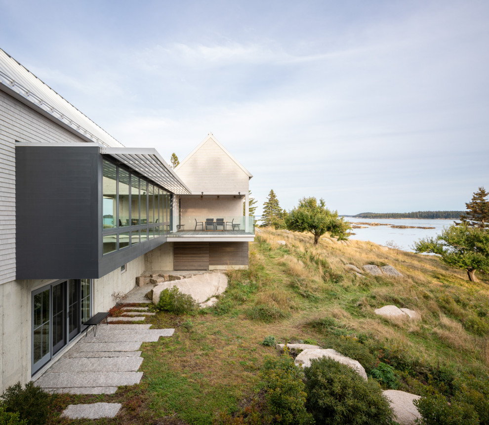 Diseño de fachada de casa minimalista de dos plantas con revestimiento de madera, tejado a dos aguas y tejado de metal