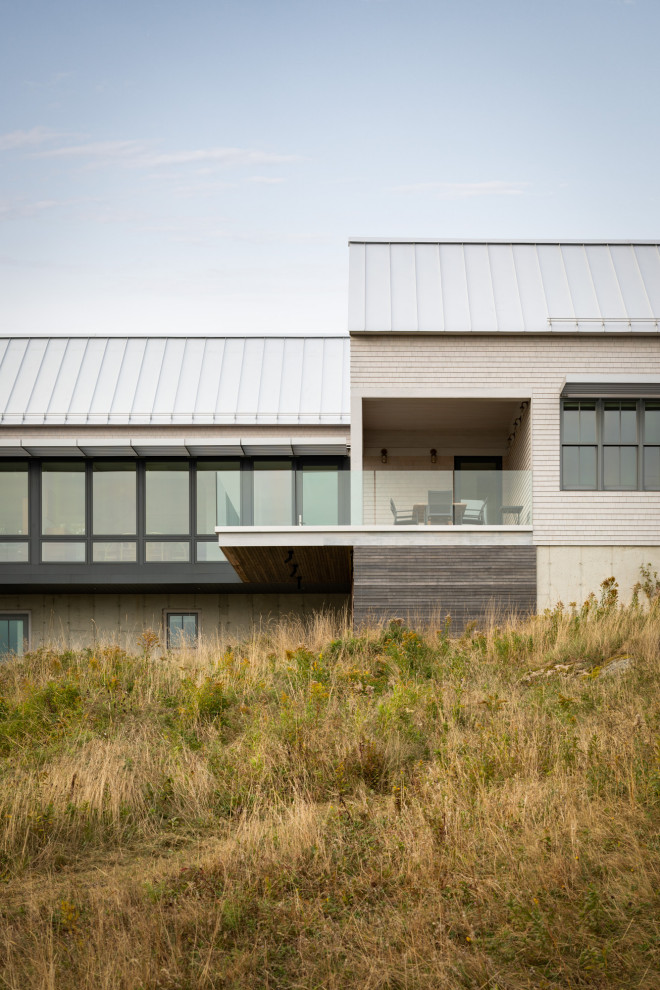 Imagen de fachada de casa minimalista de dos plantas con revestimiento de madera, tejado a dos aguas y tejado de metal