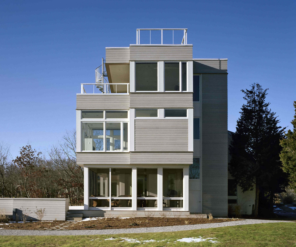 Aménagement d'une façade de maison grise contemporaine à deux étages et plus.