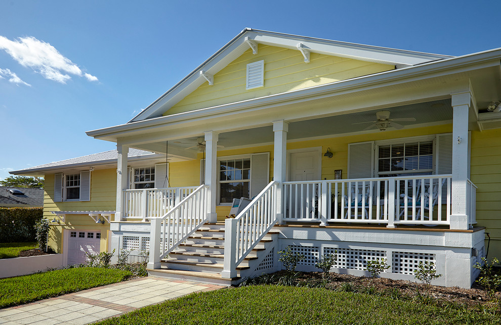 Inspiration for a mid-sized timeless yellow two-story wood gable roof remodel in Miami