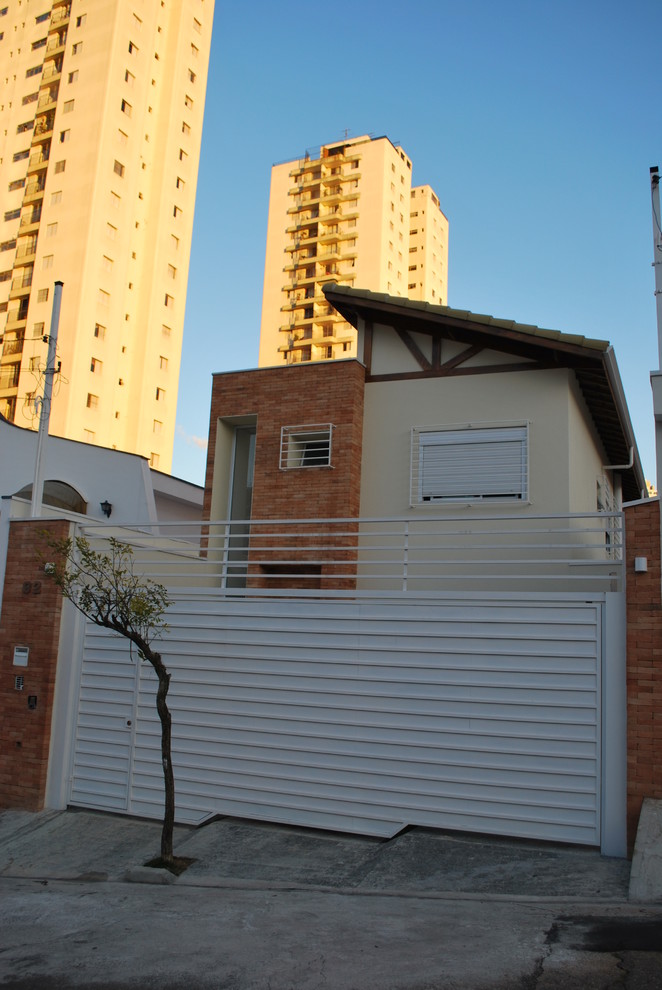 Exemple d'une petite façade de maison beige tendance en brique à un étage.