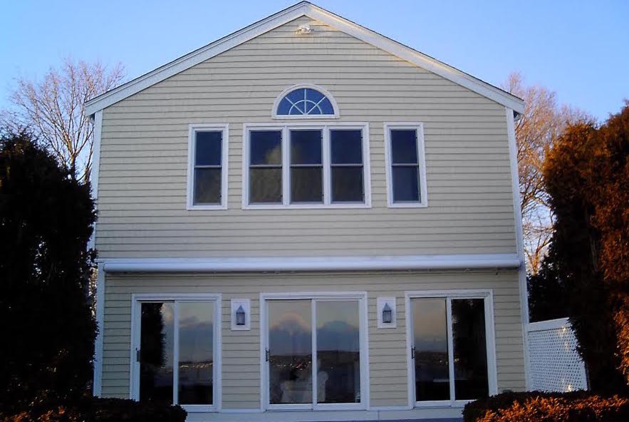 Inspiration for a large and yellow nautical two floor house exterior in Providence with wood cladding and a pitched roof.