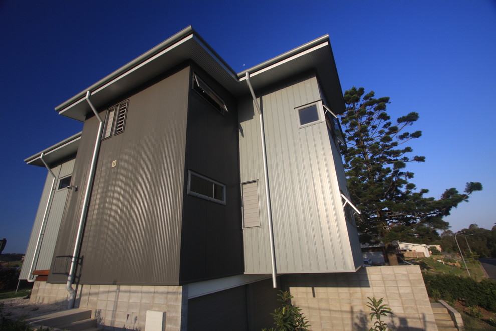 Design ideas for a gey beach style two floor house exterior in Gold Coast - Tweed with metal cladding and a flat roof.