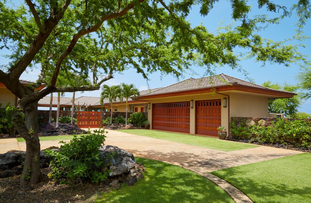 Design ideas for an expansive and beige world-inspired bungalow render house exterior in Hawaii with a hip roof.
