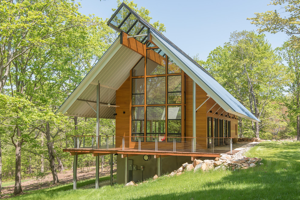 Esempio della facciata di una casa contemporanea con rivestimento in legno e tetto a capanna