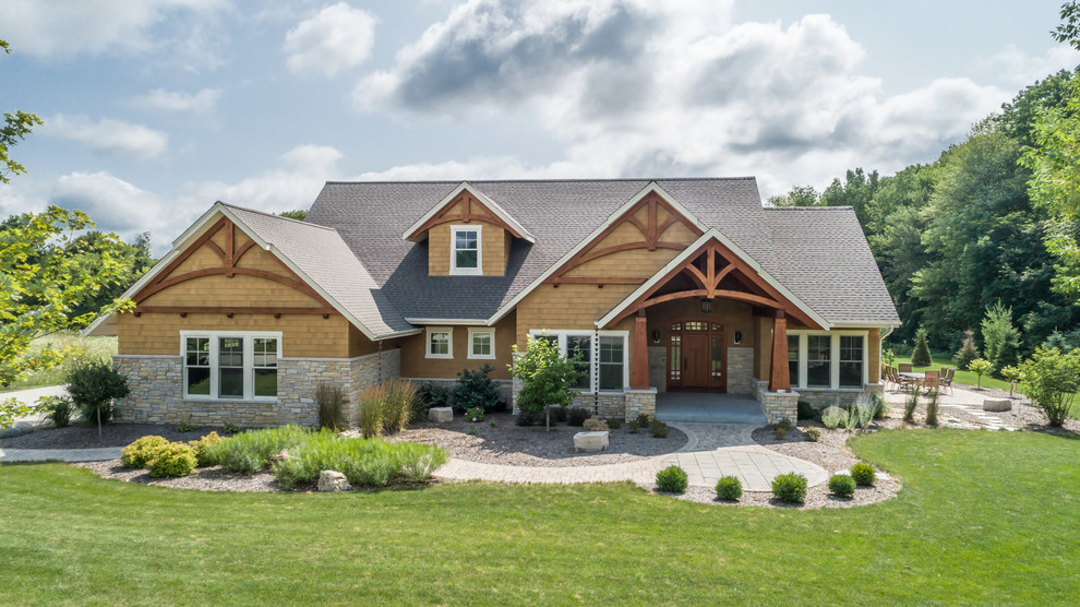 Modelo de fachada de casa marrón de estilo americano grande de una planta con revestimientos combinados, tejado a doble faldón y tejado de teja de madera