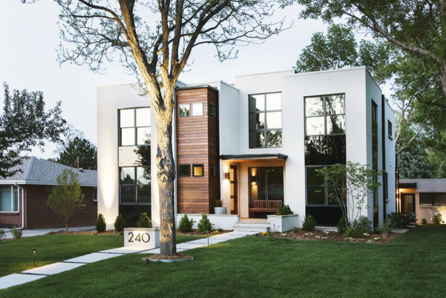 Cette photo montre une façade de maison beige tendance en stuc de taille moyenne et à un étage avec un toit plat.