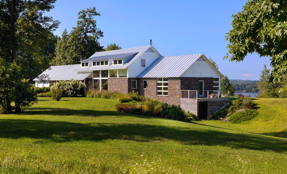 Diseño de fachada de casa multicolor contemporánea de tamaño medio de dos plantas con revestimiento de piedra, tejado de un solo tendido y tejado de metal