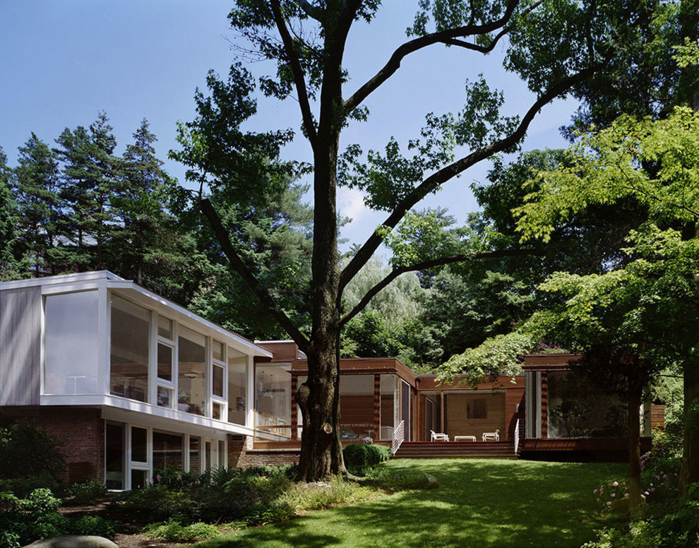 Inspiration pour une façade de maison marron minimaliste de taille moyenne et à un étage avec un revêtement mixte et un toit plat.
