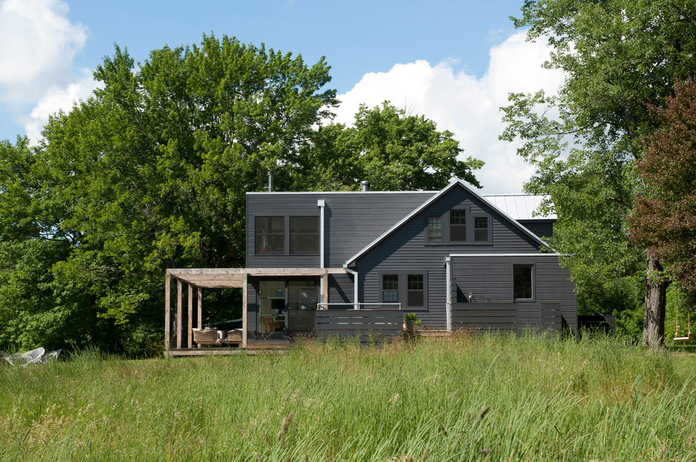 Inspiration pour une façade de maison noire design en bois de taille moyenne et à un étage avec un toit plat.