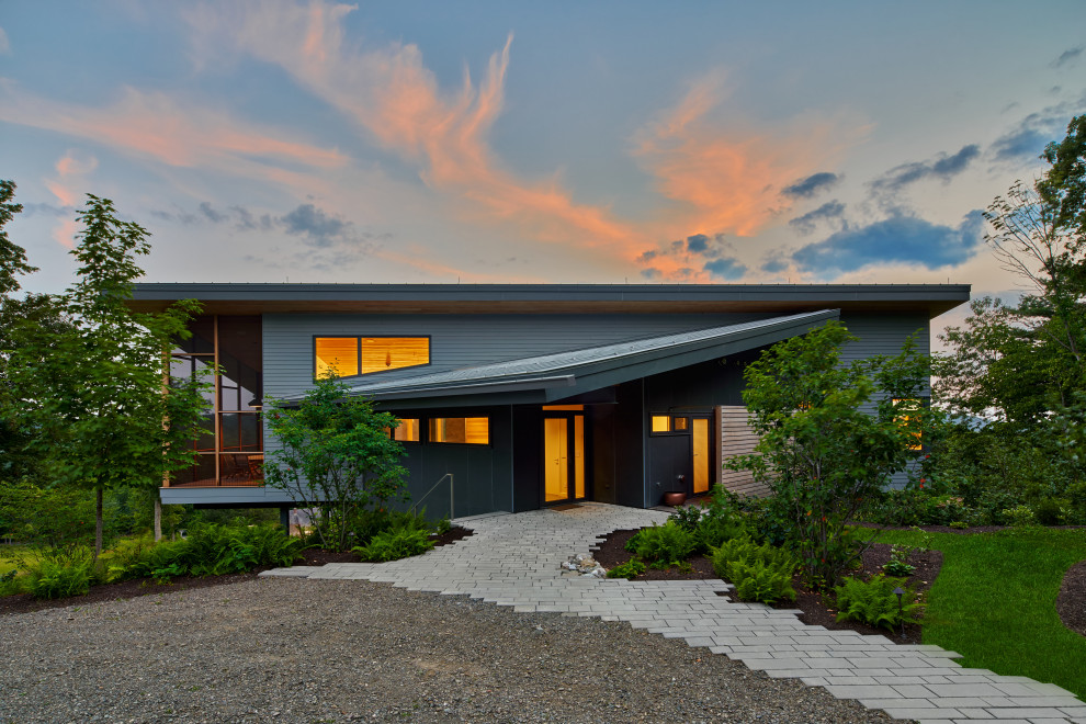 Réalisation d'une façade de maison grise design avec un toit en appentis.