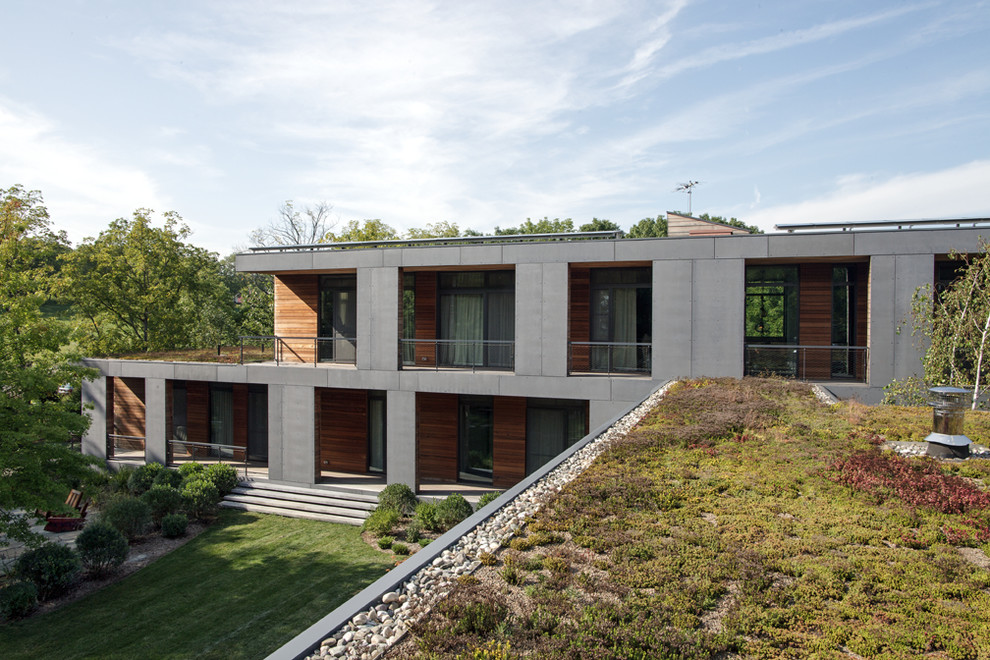 Ispirazione per la villa grande grigia moderna a due piani con rivestimento in cemento, tetto piano e copertura verde