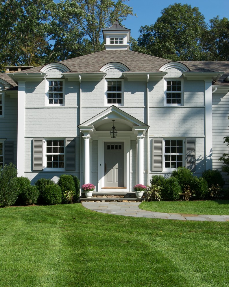 Idee per la facciata di una casa bianca classica a due piani con rivestimento in mattoni
