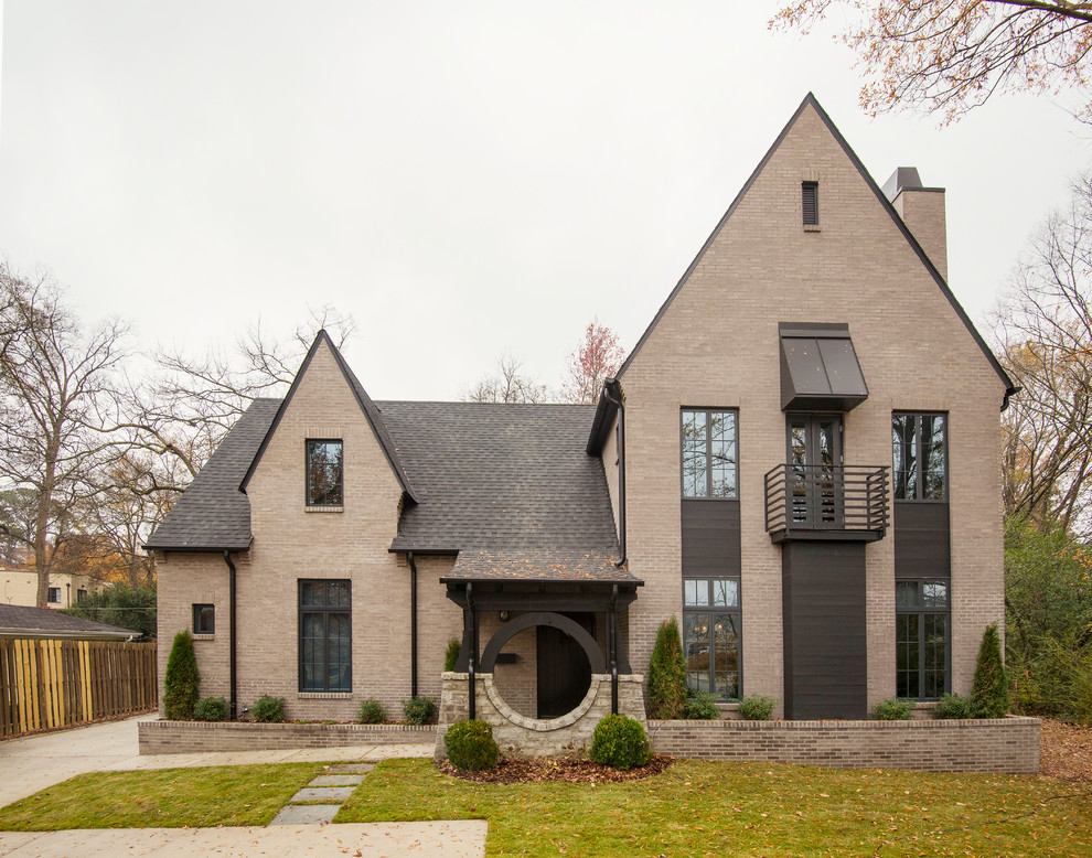 Exemple d'une façade de maison beige tendance en brique avec un toit en shingle.