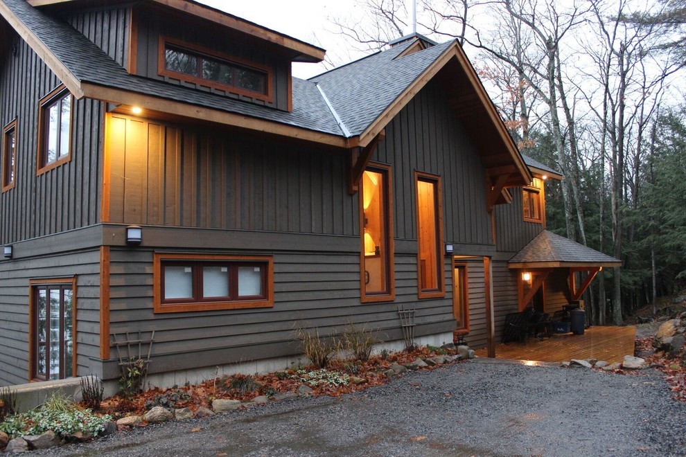 Diseño de fachada gris de estilo americano grande de dos plantas con revestimiento de madera y tejado a dos aguas