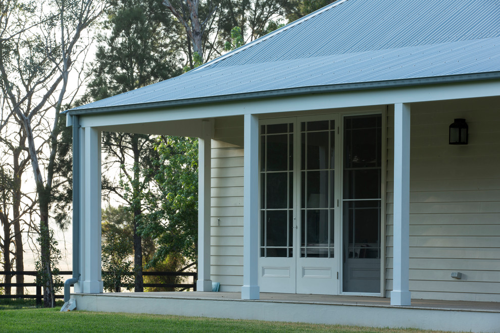 Photo of a large and beige rural bungalow house exterior in Newcastle - Maitland with wood cladding.