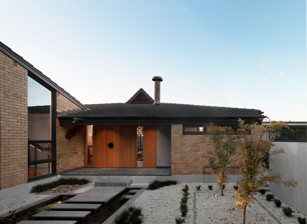 Immagine della villa ampia beige moderna a due piani con rivestimento con lastre in cemento, tetto a padiglione e copertura in tegole