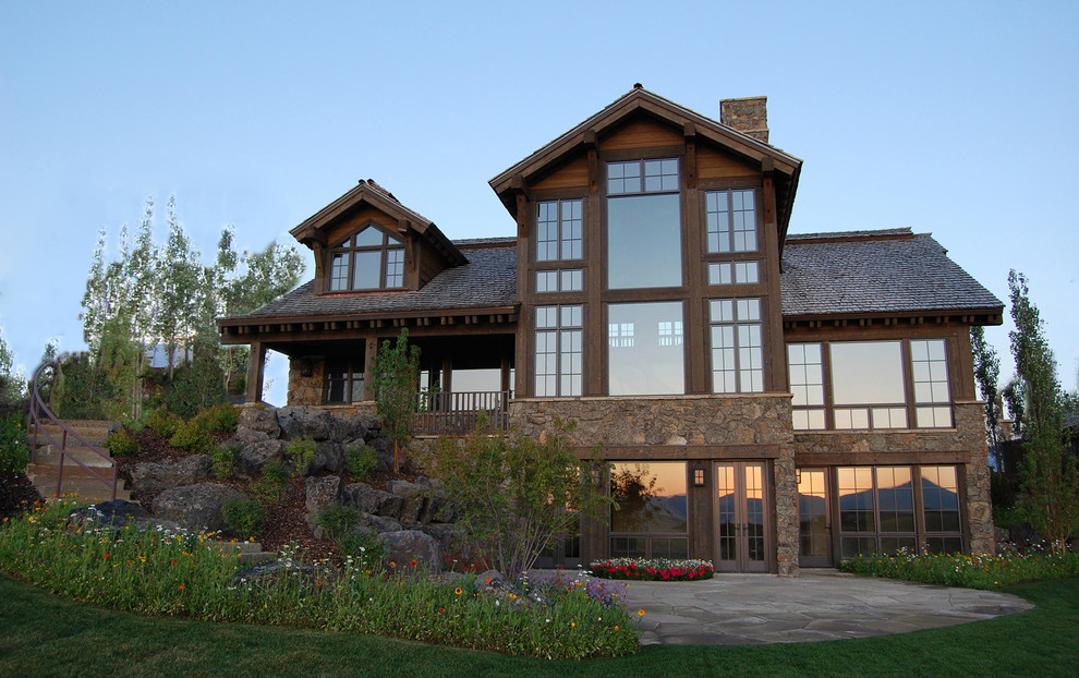 Foto de fachada de casa marrón rural grande de dos plantas con revestimientos combinados, tejado a dos aguas y tejado de teja de madera