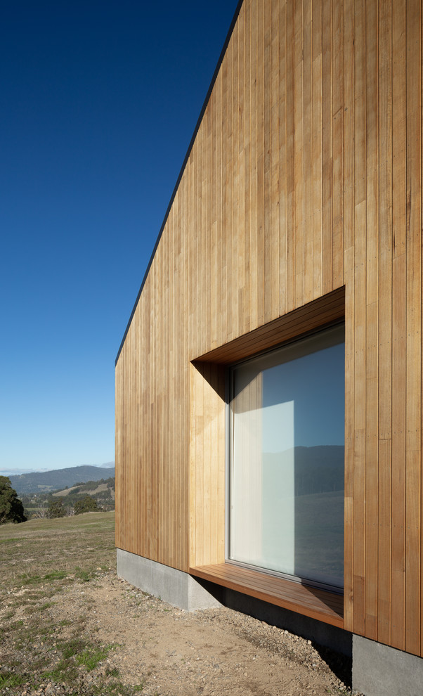 Réalisation d'une grande façade de maison beige champêtre en bois de plain-pied avec un toit à deux pans et un toit en métal.