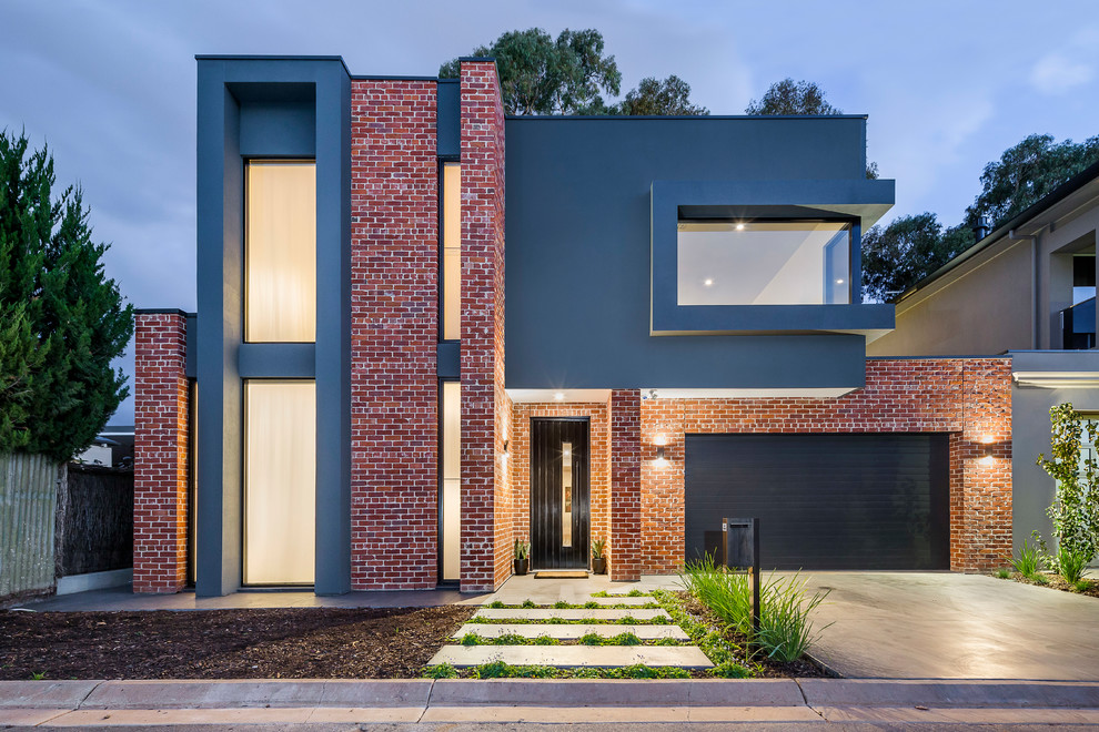 Свежая идея для дизайна: двухэтажный, кирпичный, красный частный загородный дом в современном стиле с плоской крышей и металлической крышей - отличное фото интерьера